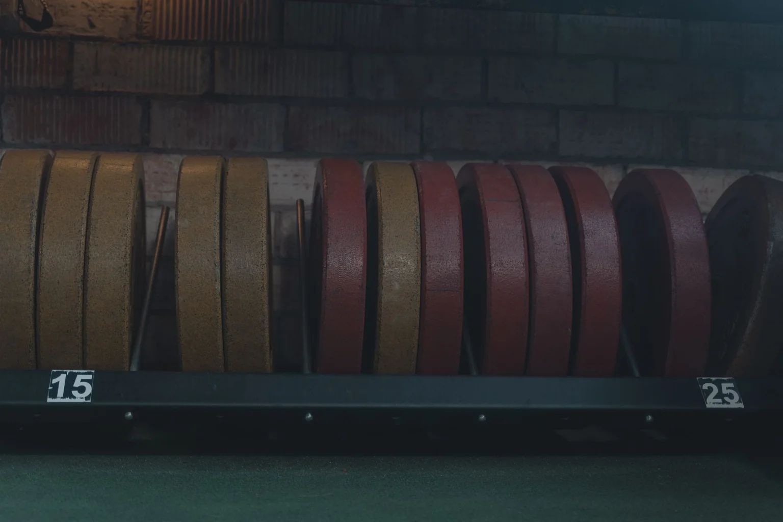 Rows of red and yellow weight plates stored on a rack
